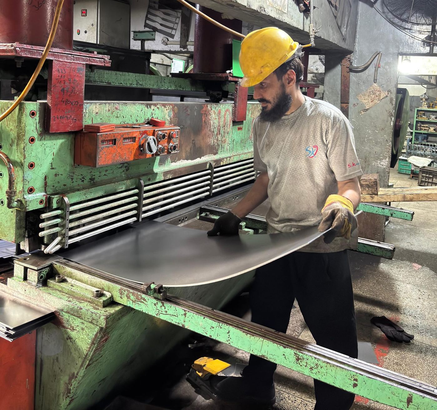 Industrial sheet metal shearing machine in operation at Halfman Engineering